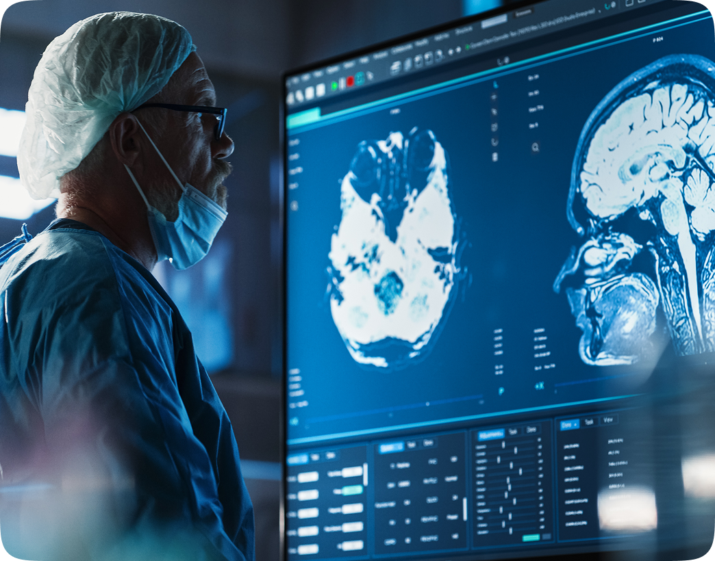 Doctor examining brain scans on monitor.